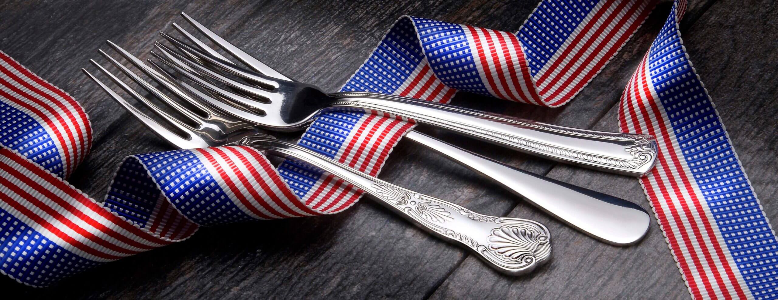 Photo of 3 forks and a red, white and blue ribbon.