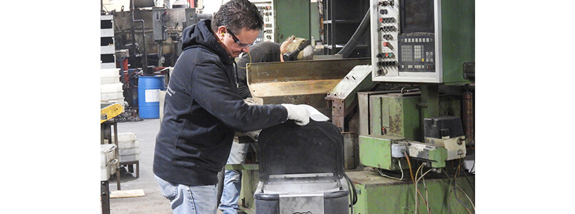 ON THE FLOOR - Sherrill Manufacturing President and co-founder Matthew Roberts checks the levels in dry ice blasting equipment used to clean a recently purchased machine that will be refurbished and used to produce knives at the factory.