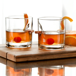 Bullet Rocks Glass Set of Two shown with whiskey and twist of orange and a cherry in a serving tray