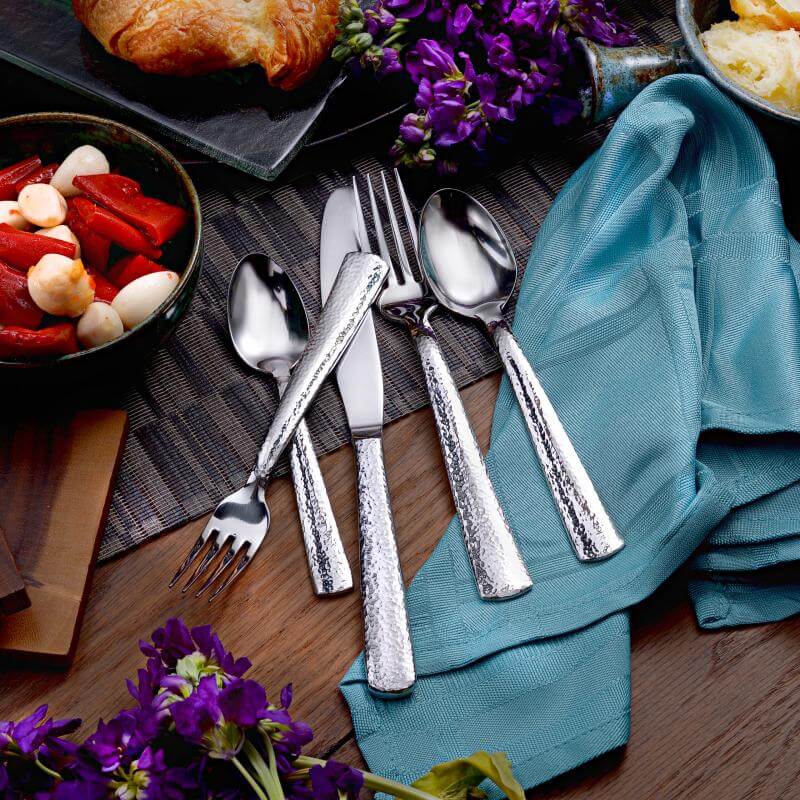 Pinehurst solid dinner knife 5-piece place setting flatware set shown on a decorative table